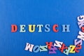 DEUTSCH word on blue background composed from colorful abc alphabet block wooden letters, copy space for ad text. Learning english Royalty Free Stock Photo