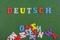 DEUTSCH word on green background composed from colorful abc alphabet block wooden letters, copy space for ad text. Learning Royalty Free Stock Photo