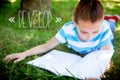 Develop against cute little girl reading in park