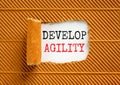Develop agility symbol. Concept words Develop agility on beautiful white paper on a beautiful brown paper background. Business, Royalty Free Stock Photo