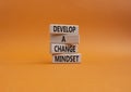 Develop a change mindset symbol. Concept words Develop a change mindset on wooden blocks. Beautiful orange wbackground. Business
