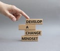 Develop a change mindset symbol. Concept words Develop a change mindset on wooden blocks. Beautiful grey background. Businessman