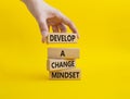 Develop a change mindset symbol. Concept words Develop a change mindset on wooden blocks. Beautiful yellow background. Businessman