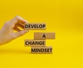 Develop a change mindset symbol. Concept words Develop a change mindset on wooden blocks. Beautiful yellow background. Businessman