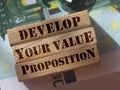 Develop your value proposition on wooden building blocks standing on 100 Euro bills. Business marketing concept Royalty Free Stock Photo