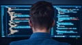 Developer Coding on Dual Monitors in Dark Room