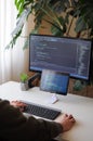 Developer is coding using screen and tablet. Freelancer is working from home Royalty Free Stock Photo