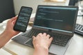Developer connecting smartphone with laptop
