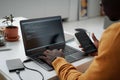 Developer connecting smartphone with laptop to work with codes