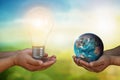 Developer hand holding light bulb and hand holding blue earth globe over blurred green nature background:f energy and earth day Royalty Free Stock Photo