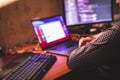 IT developer programmer working and coding on his worplace at home, laptop and desktop monitor pc with coding software program app Royalty Free Stock Photo