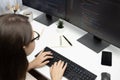 IT developer woman coding on laptop screen at back side view. Postulate. Royalty Free Stock Photo