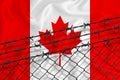 Developing Canada Flag, mesh fence and barbed wire. Concept of isolation of emigrants. With place for your text Royalty Free Stock Photo