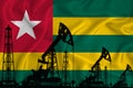 Developing Flag of togo. Silhouette of drilling rigs and oil rigs on a flag background. Oil and gas industry. The concept of oil