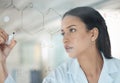 Developing a working cure takes hard work. a young scientist solving equations on a glass screen in a lab. Royalty Free Stock Photo