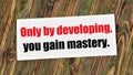 Only by developing, you gain mastery. Text inscription in the banner plate.