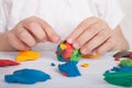 Development of small motor skills of children. A child sculpts a colorful ball of plasticine