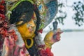 A Devi Maa Durga sadly looks down with tousled hair while tears flow the eyes during Durga Maa visarjan or immersion at Ganga or Royalty Free Stock Photo