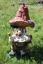 Device for watering a lawn in the form of a gnome with a shovel under the mushroom