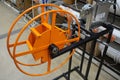 THE DEVICE FOR WINDING A FLEXIBLE ELECTRICAL CABLE INSTALLED IN A BUILDING MATERIALS STORE IS ORANGE. INDUSTRIAL AND CIVIL