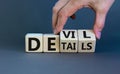 Devil in the details symbol. Businessman hand turns cubes and changes the word `details` to `devil`. Beautiful grey background