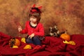 Devil girl is having fun for Halloween with pumpkins and hat Royalty Free Stock Photo