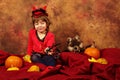 Devil girl is having fun for Halloween with pumpkins and hat Royalty Free Stock Photo