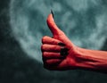 Devil hand with thumb up gesture at midnight Royalty Free Stock Photo