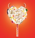 Devil heart Milk shake lolipop with sweets and whipped cream, front view. Sweet devil lolipop concept with whipped cream