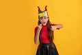 devil kid with pumpkin. trick or treat. teen girl point finger on yellow background. Royalty Free Stock Photo