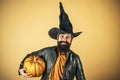 Devil man. Thanksgiving seasonal cooking ingredients. Portrait of Handsome man with pumpkin over  background Royalty Free Stock Photo