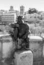 Devil statue taking a selfie against the ancient Roman aqueduct of Segovia, Spain