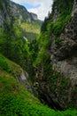 Devil throat Cave, or Dyavolsko Garlo, Bulgaria, Western Rhodopes. Summer day in Bulgaria. River Landscape with green hills. Tr