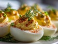 Deviled eggs garnished with paprika, fresh dill, and chopped chives served as an elegant appetizer on a white plate for festive Royalty Free Stock Photo
