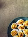 Devilled eggs on blue plate and grey background