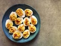 Devilled eggs on blue plate and grey background