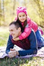 Devoted father and daughter lying on grass, enjoying each others company, bonding, playing, having fun in nature on a bright, Royalty Free Stock Photo