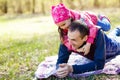 Devoted father and daughter lying on grass, enjoying each others company, bonding, playing, having fun in nature on a bright, Royalty Free Stock Photo