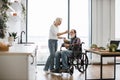 Devoted woman feeds man in wheelchair with fresh healthy salad. Royalty Free Stock Photo