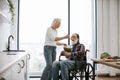 Devoted woman feeds man in wheelchair with fresh healthy salad. Royalty Free Stock Photo