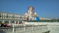 Devotees walking around the white clock tower building