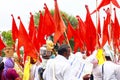 Devotees walking in a pilgrimage carrying various orange color flags