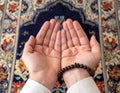 Devotional Prayer Hands Facing Upwards with Prayer Beads on Decorative Carpet Royalty Free Stock Photo
