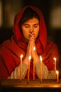 Devout Christian Woman with Head Scarf Lighting a Candle in Church, Praying and Expressing Devotion Royalty Free Stock Photo