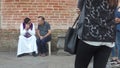 Devout old man confessing to a Roman Catholic priest outside the church wall