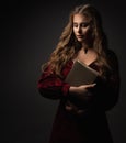 Devout Woman with Holy Bible. Medieval Lady holding Old Book over Black. Praying Catholic Girl in antique style Dress. Worship. Royalty Free Stock Photo