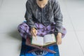 Devout young muslim man reading Koran