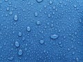 Dew drops on blue surface Royalty Free Stock Photo