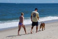 Dewey Beach, Delaware, U.S.A - August 13, 2022 - A couple walking with their dog on the beach