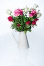 Dewy white, red and pink roses in vintage beige watering can Royalty Free Stock Photo